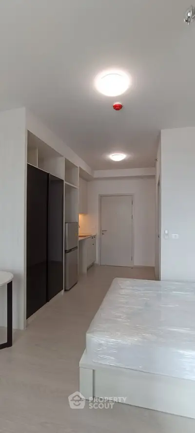 Modern studio apartment with sleek design and built-in storage solutions.
