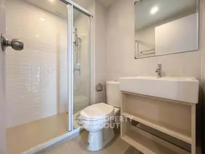 Modern bathroom with glass shower and sleek fixtures in a contemporary home.