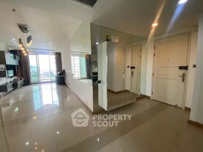 Spacious modern living room with large windows and mirrored wall