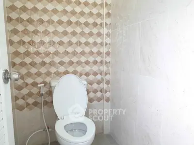 Modern bathroom with stylish tile design and clean white toilet