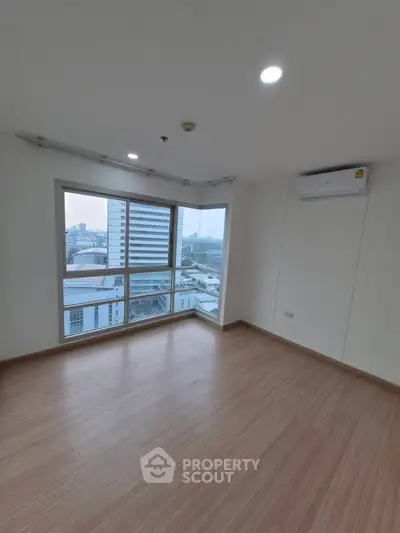 Spacious empty room with large windows and city view, perfect for customization.