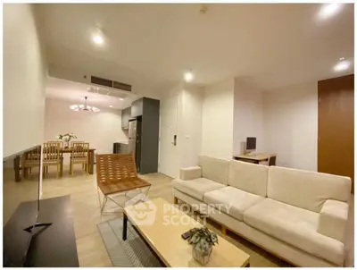 Spacious modern living room with elegant furniture and open dining area, perfect for comfortable living.