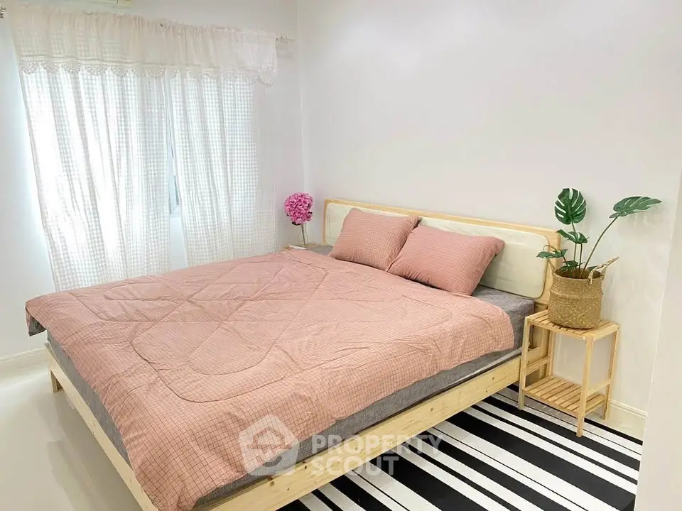 Cozy bedroom with stylish decor and natural light, featuring a comfortable bed and modern furnishings.