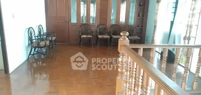 Spacious living room with wooden flooring and elegant chairs, perfect for family gatherings.