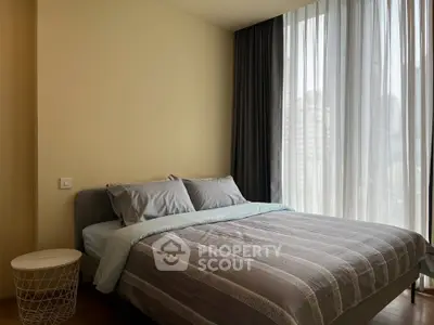 Cozy bedroom with large window and modern decor in urban apartment