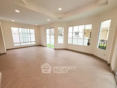Spacious modern living room with large windows and elegant flooring