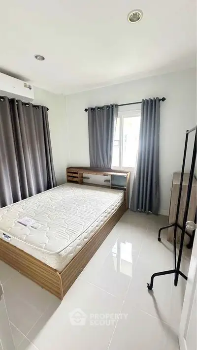 Modern bedroom with sleek design, featuring a large window and stylish furnishings.