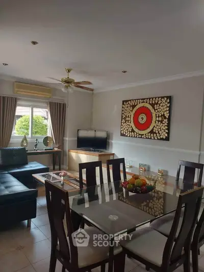 Stylish living room with modern dining set and wall art, featuring natural light and elegant decor.