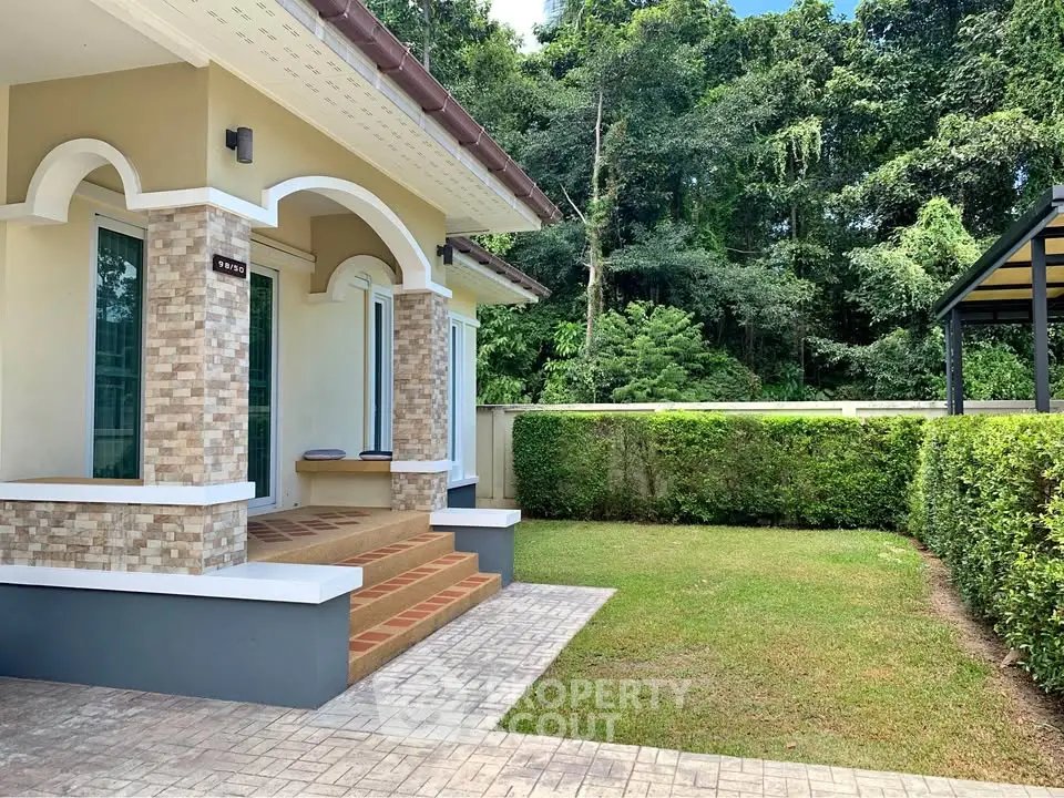 Charming single-story home with lush garden and elegant entrance in tranquil setting.
