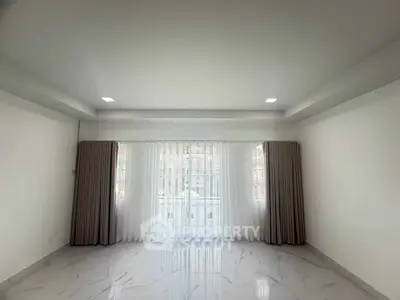 Spacious living room with elegant curtains and marble flooring, perfect for modern living.