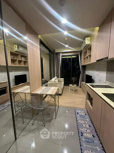 Modern open-layout kitchen and living area with city view, featuring sleek cabinetry and stylish decor.