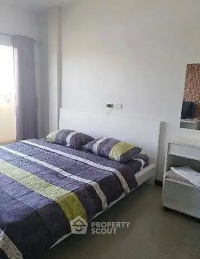 Cozy bedroom with modern decor and ample natural light, perfect for relaxation and comfort.
