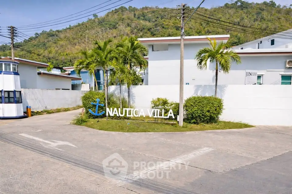 Charming Nautica Villa entrance with lush greenery and mountain backdrop.