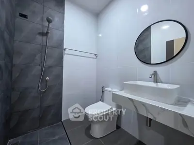 Modern bathroom with sleek design, featuring a walk-in shower and elegant fixtures.