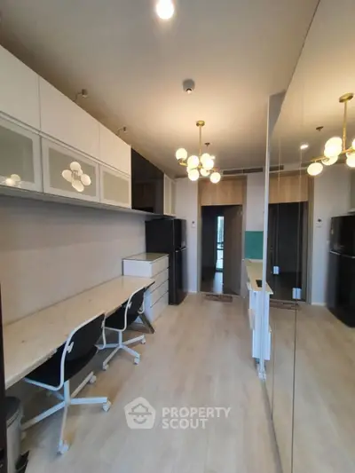 Modern kitchen with sleek cabinetry and stylish lighting in a contemporary apartment.