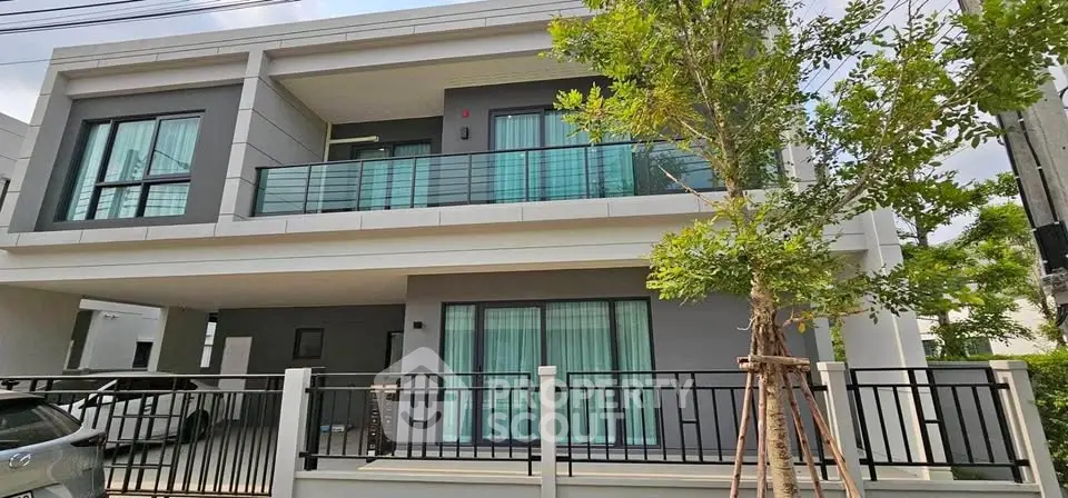 Modern two-story house with balcony and large windows, featuring sleek design and contemporary architecture.