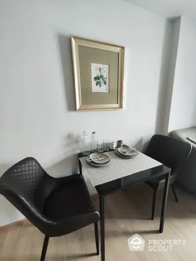 Cozy dining nook with elegant chairs and framed artwork, perfect for intimate meals.