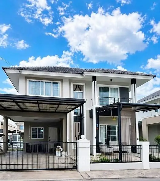 Modern two-story house with a spacious driveway and elegant facade under a bright blue sky.