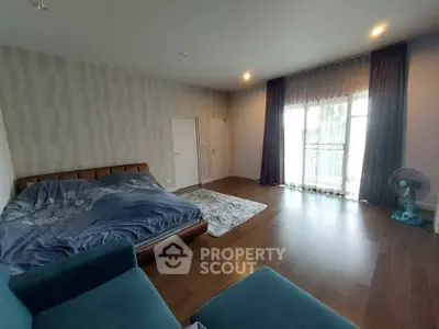 Spacious bedroom with modern decor and large window for natural light.