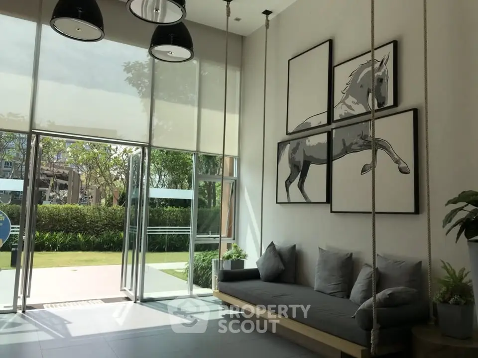 Modern lobby with stylish decor and large windows opening to a lush garden view.