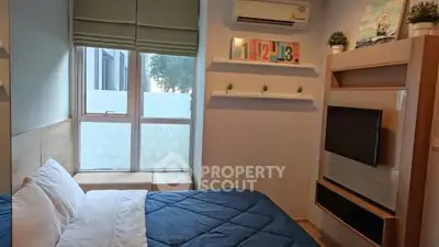 Cozy bedroom with modern decor and large window for natural light.