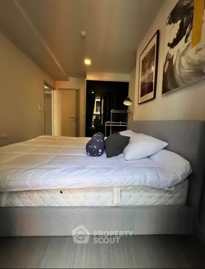 Modern bedroom with stylish decor and cozy ambiance, featuring a comfortable bed and elegant artwork.
