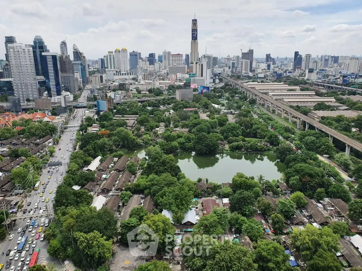 Stunning aerial view of urban skyline with lush greenery and serene water bodies, showcasing city living at its finest.