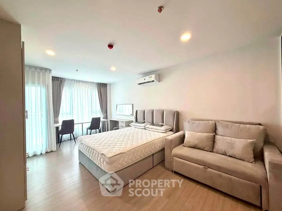 Modern bedroom with cozy sofa and natural light in stylish apartment