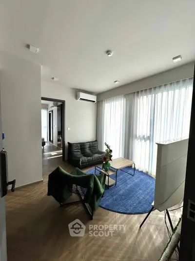 Modern living room with stylish furniture and large windows offering natural light.