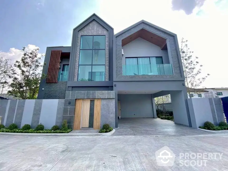 Modern two-story house with large windows and spacious driveway