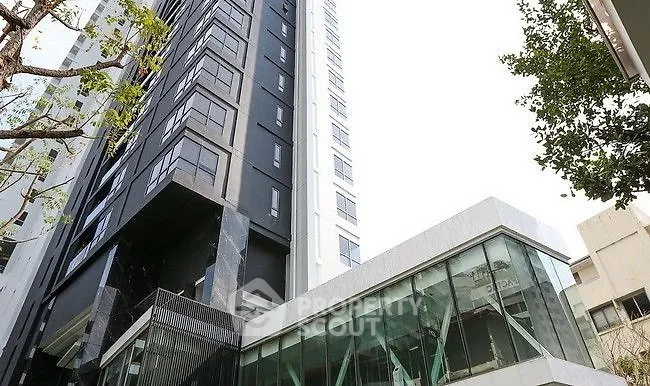 Modern high-rise building with sleek glass facade and contemporary design.