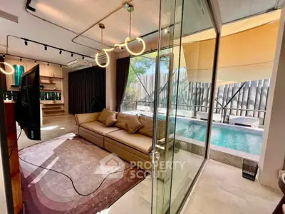 Luxurious living room with pool view, modern decor, and elegant lighting in a stylish home.