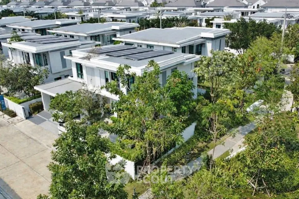Modern residential complex with lush greenery and contemporary architecture.