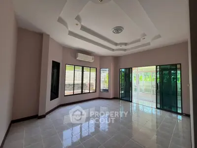 Spacious empty living room with large windows and modern ceiling design