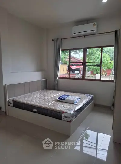 Spacious bedroom with large window and air conditioning, perfect for comfort and relaxation.