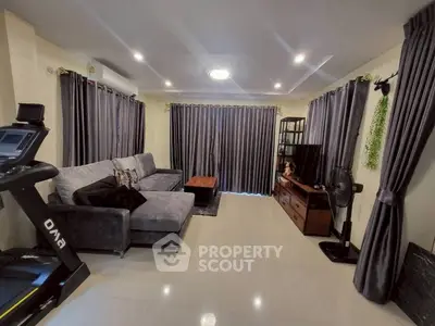 Spacious living room with modern decor and exercise equipment, ideal for relaxation and fitness.