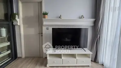 Modern living room with sleek TV stand and elegant decor, featuring natural light and stylish furnishings.