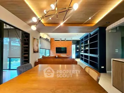 Modern living room with stylish lighting, wooden ceiling, and open layout for dining and relaxation.