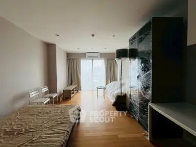 Spacious bedroom with large window and modern furnishings