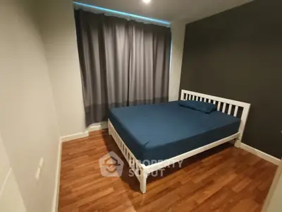 Cozy bedroom with wooden flooring and modern bed frame, perfect for restful nights.