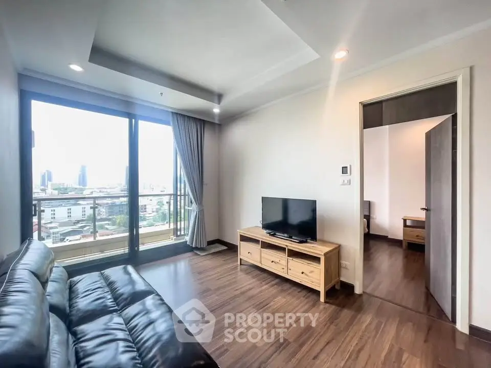 Modern living room with city view, featuring sleek leather sofa and wooden TV stand, perfect for urban living.