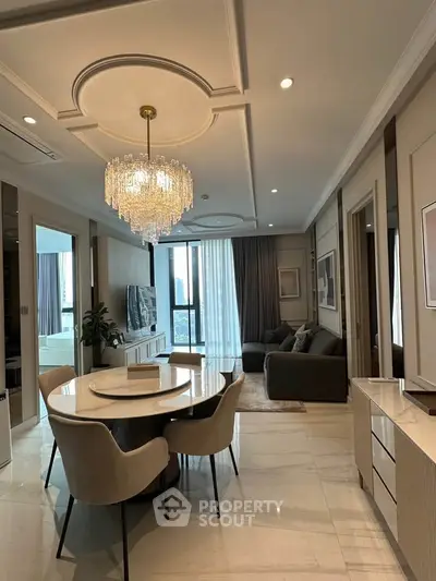 Luxurious living room with elegant chandelier and modern furniture in a high-end apartment.