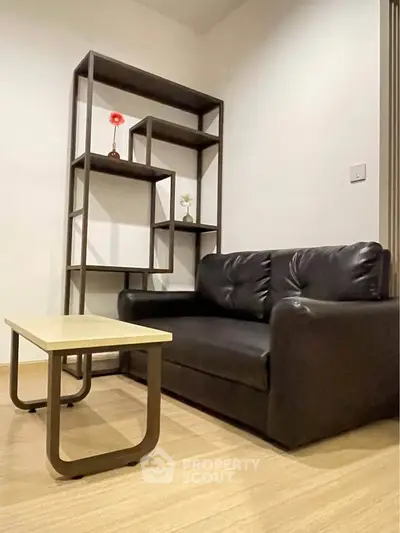 Modern living room with sleek black sofa and stylish shelving unit