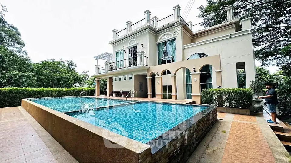 Luxurious villa with stunning pool and elegant architecture surrounded by lush greenery.