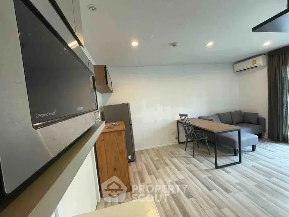 Modern living room with sleek furniture and open layout, featuring a cozy sofa and dining area.
