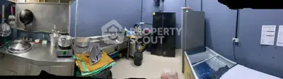 Spacious industrial kitchen with stainless steel appliances and ample storage space.