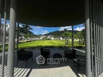 Stunning garden view from shaded patio with modern seating, perfect for relaxation and outdoor enjoyment.