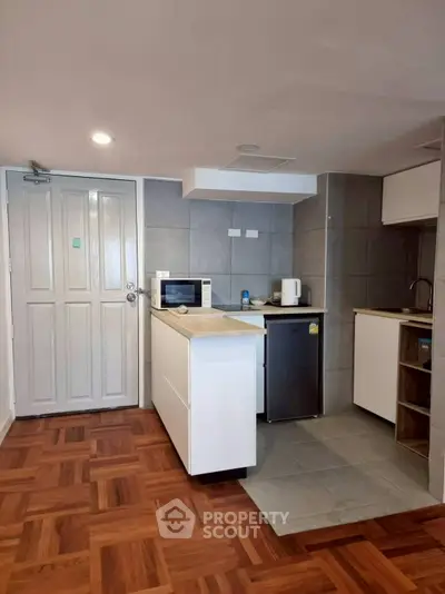 Cozy modern kitchen with parquet flooring and compact appliances