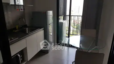 Modern kitchen with sleek appliances and balcony view in urban apartment