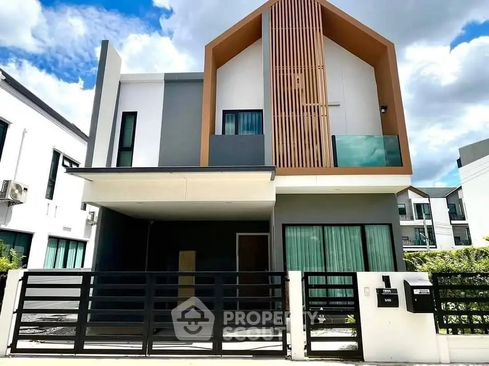 Modern two-story house with sleek design and spacious balcony in a suburban neighborhood.